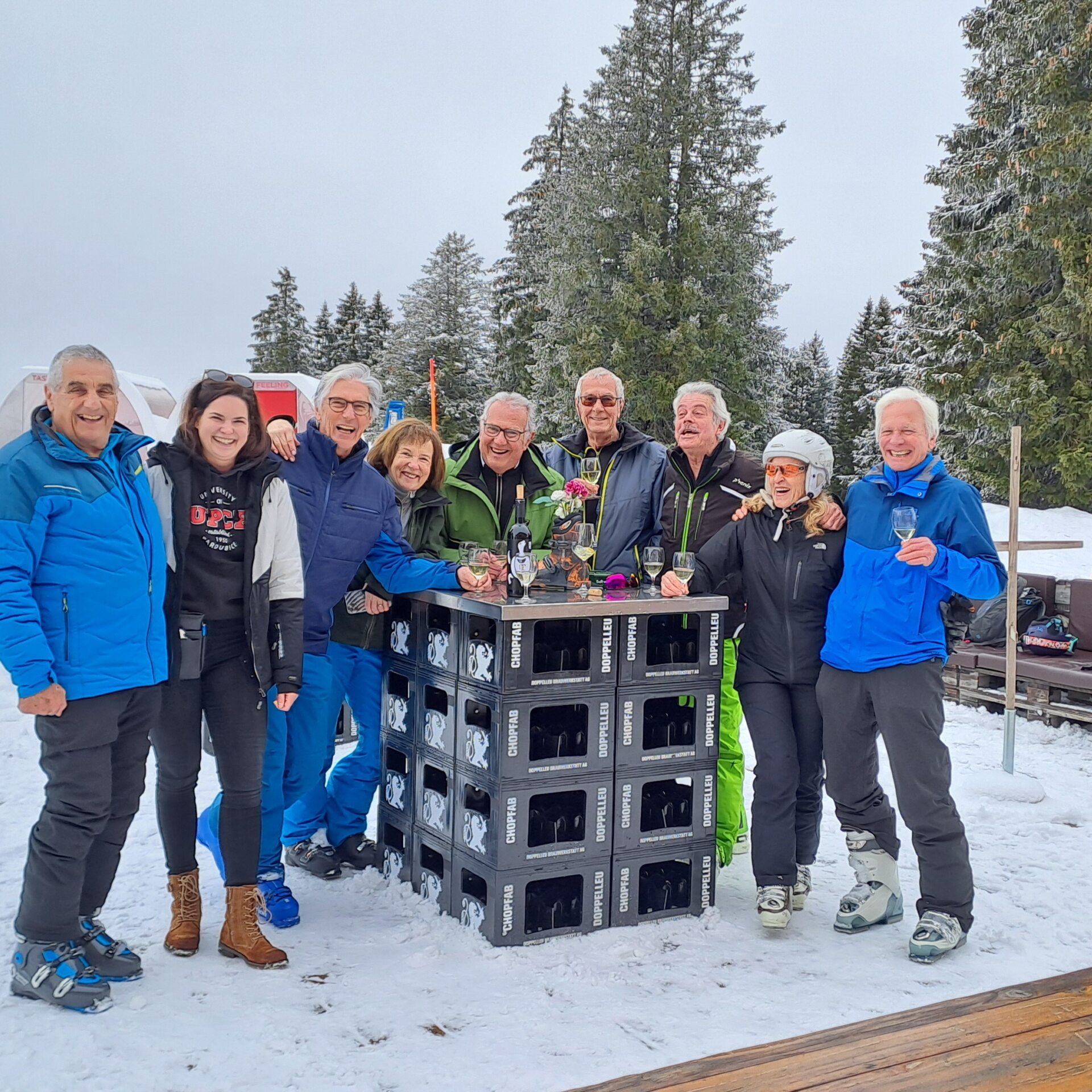 Eine Gruppe von älteren Menschen steht um einen Tisch auf der Red Fox Terrasse