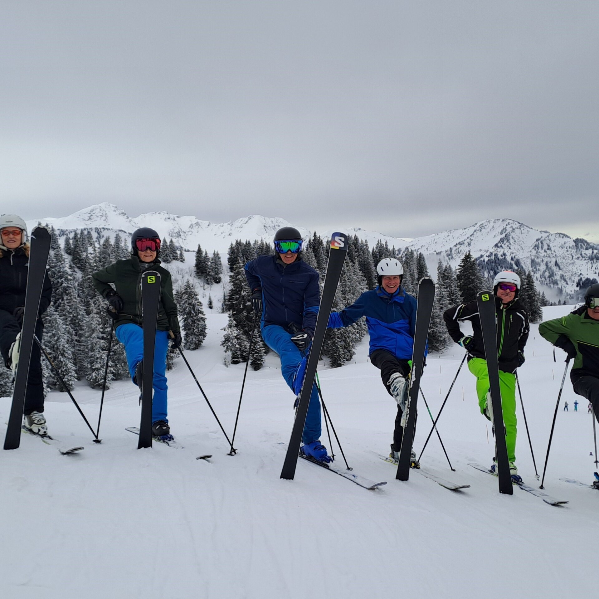 Skistamm: Acht Skifahrer stehen nebeneinander mit aufgestelltem Ski