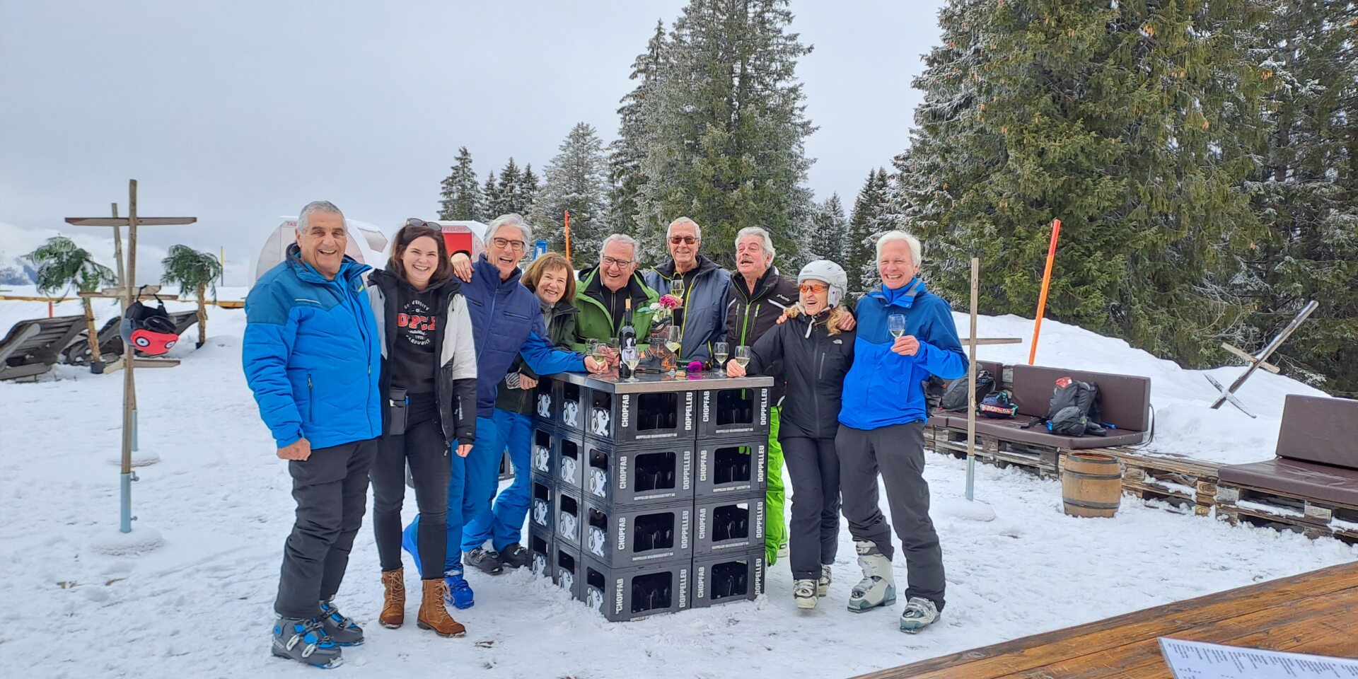 Eine Gruppe von älteren Menschen steht um einen Tisch auf der Red Fox Terrasse