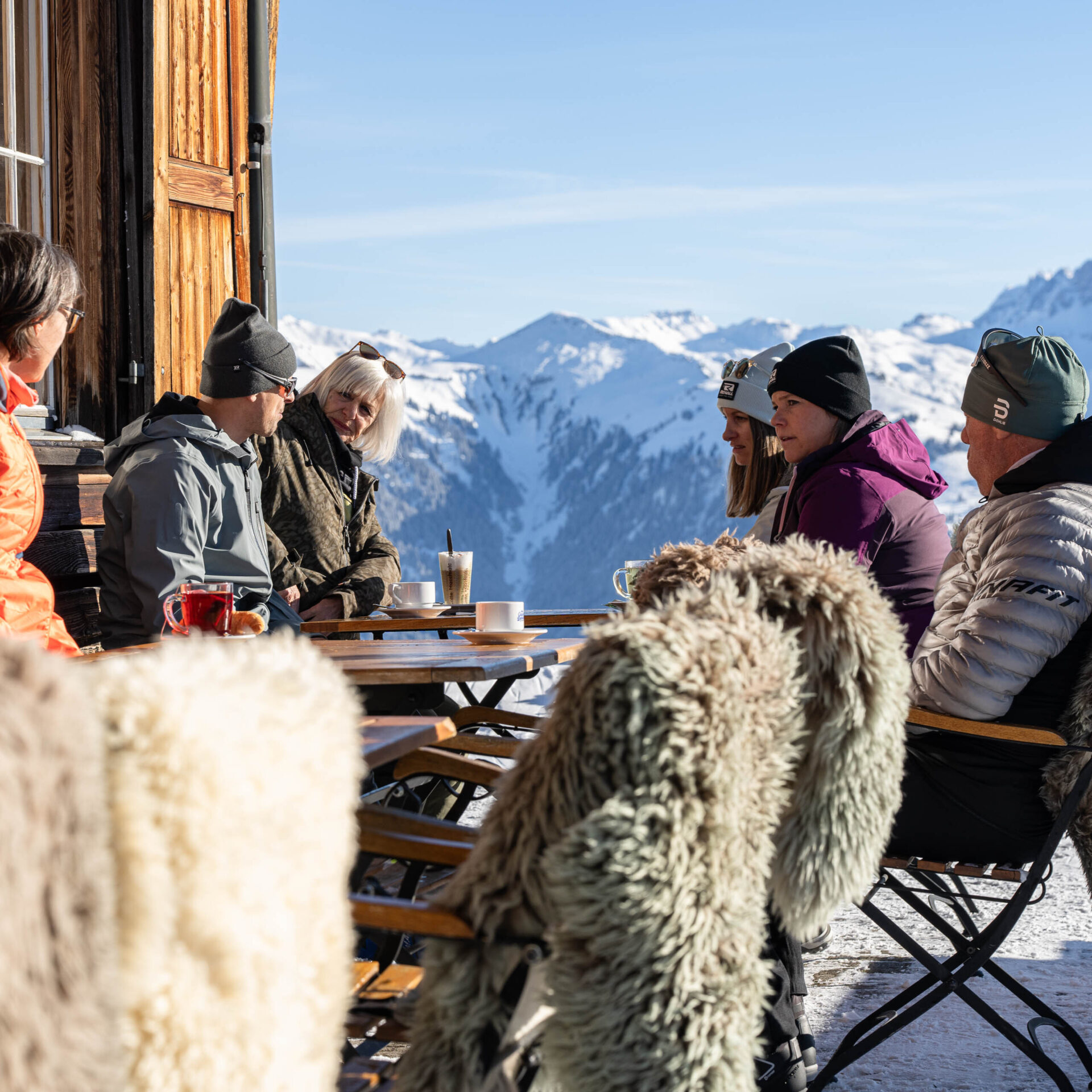 Gaeste sitzen auf der Berghaus Terrasse im Kaffee