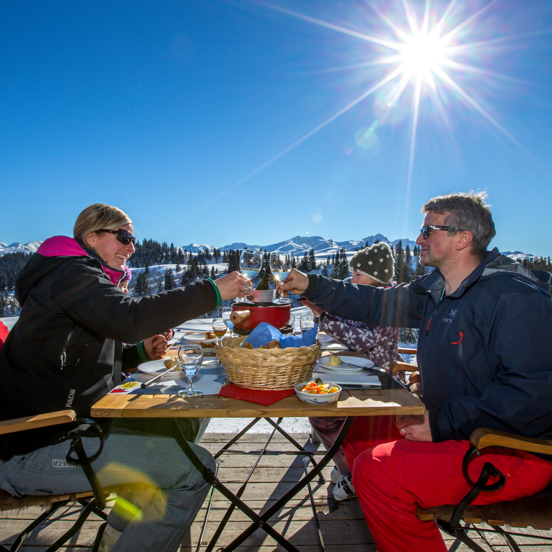 Eine Familie am Fondueessen auf der Terrasse