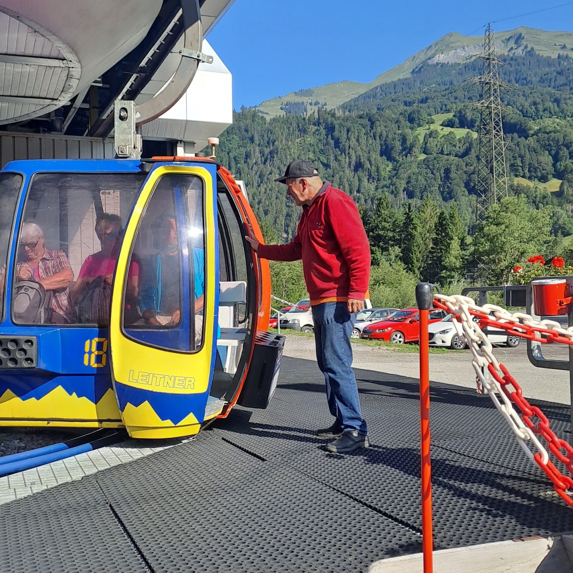 Bahnarbeiter hilft den Gästen beim Einstieg in die Gondel