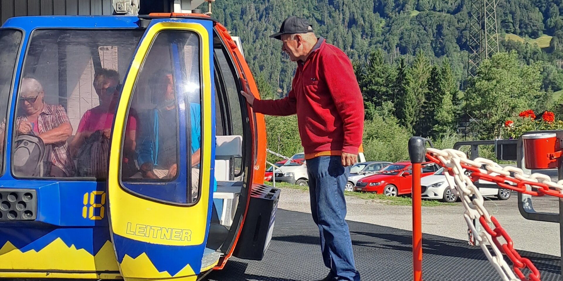 Bahnarbeiter hilft den Gästen beim Einstieg in die Gondel