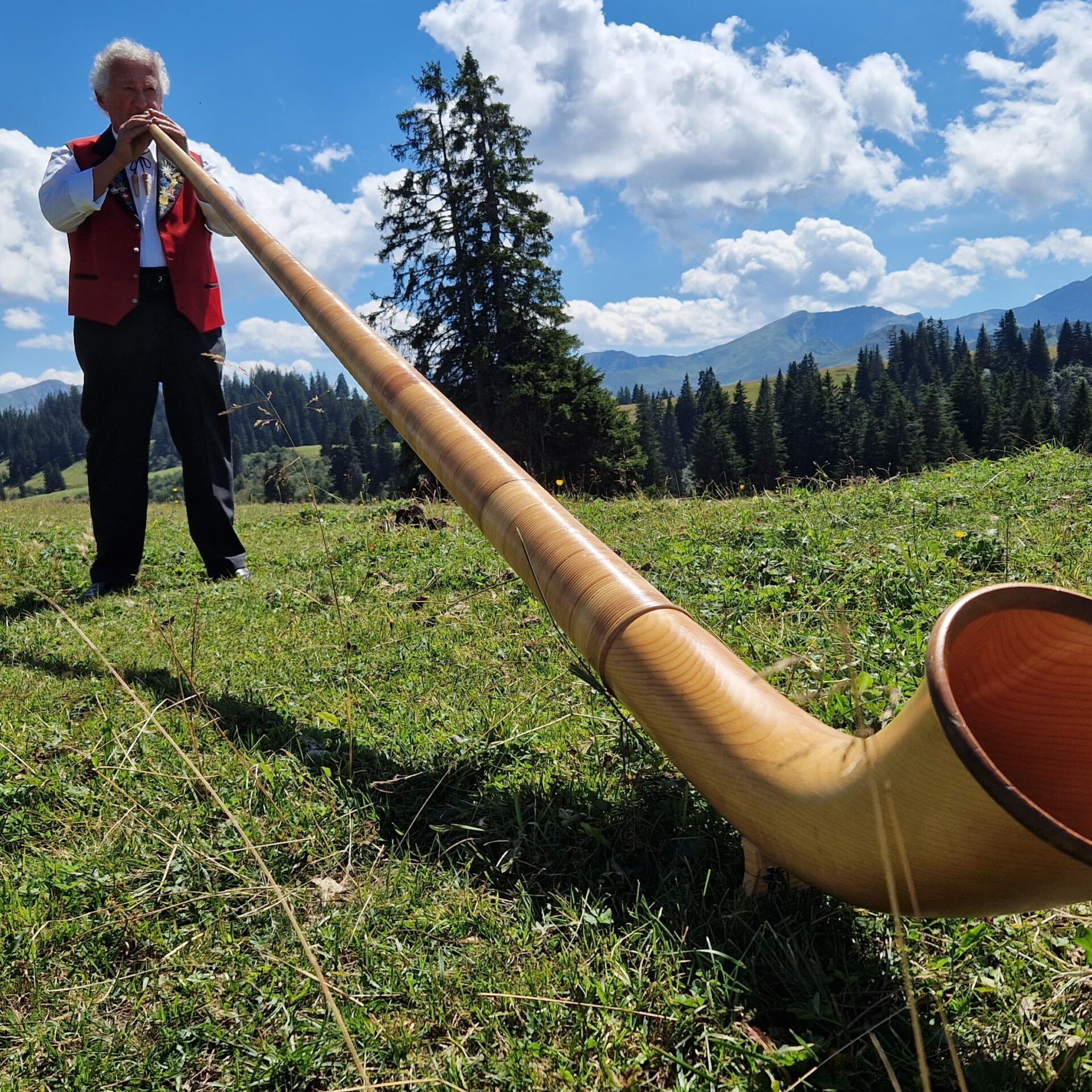 Ein Mann spielt mit dem Alphorn auf Grüsch-Danusa