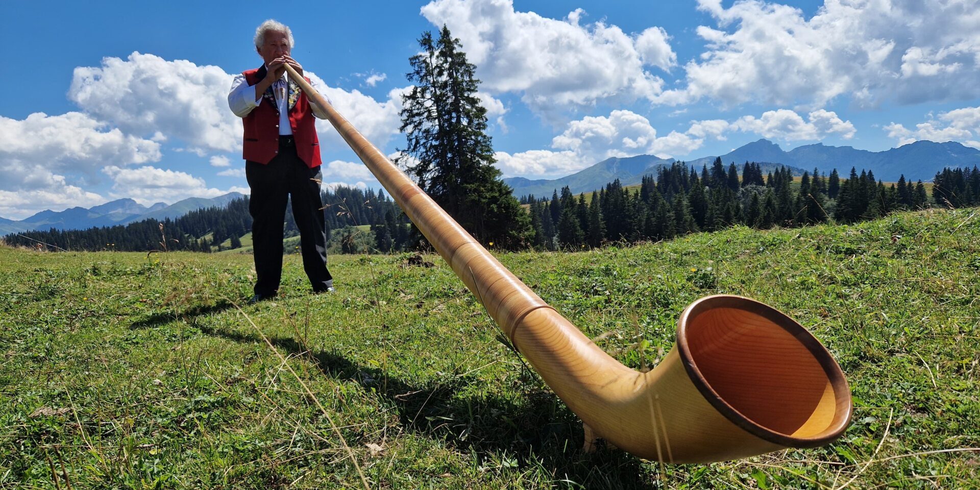 Ein Mann spielt mit dem Alphorn auf Grüsch-Danusa