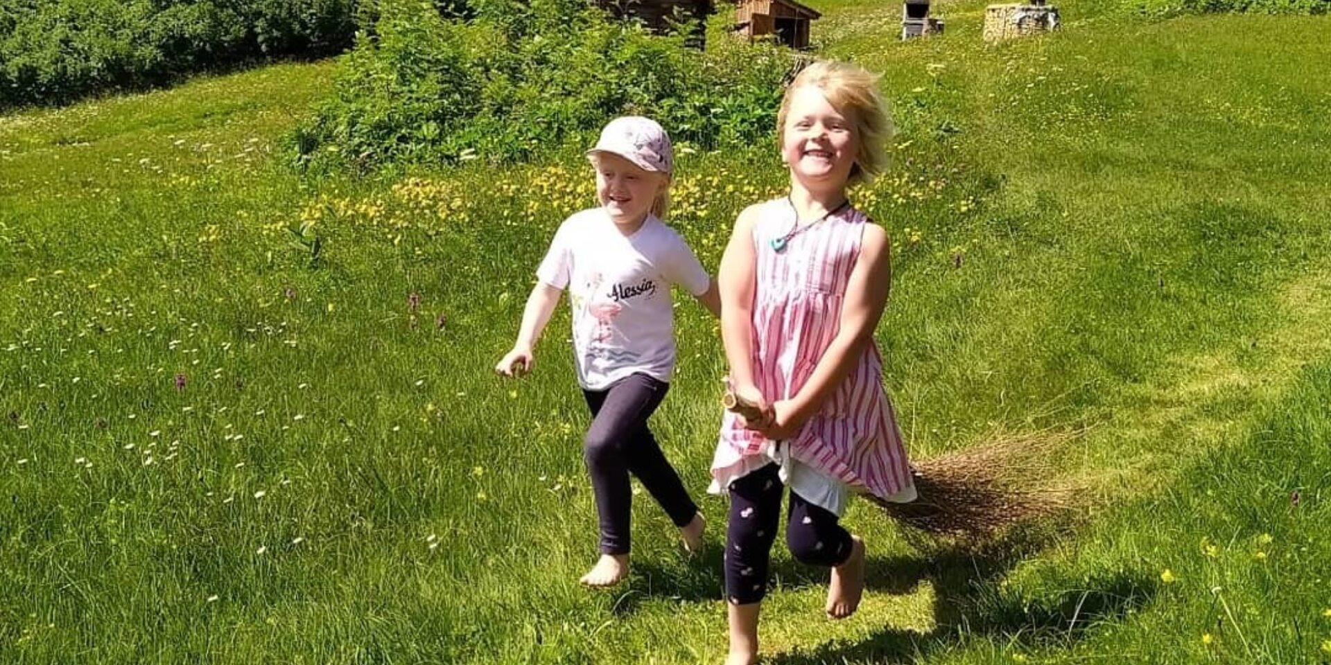 Zwei Mädchen rennen mit dem Hexenbesen auf dem Erlebnisweg