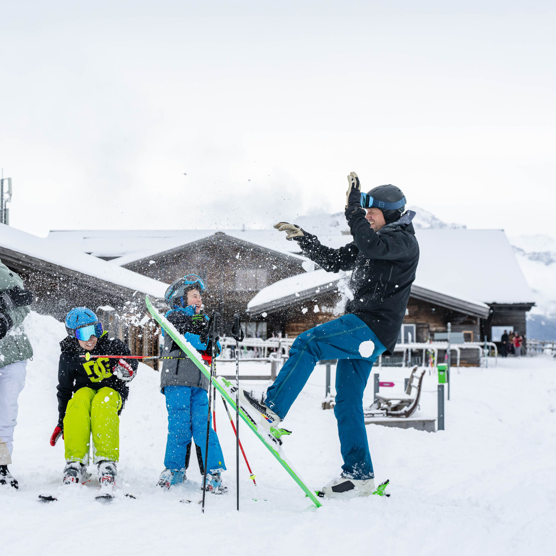 Schneeballschlacht mit dem Berghaus Schwänzelegg im Hintergrund