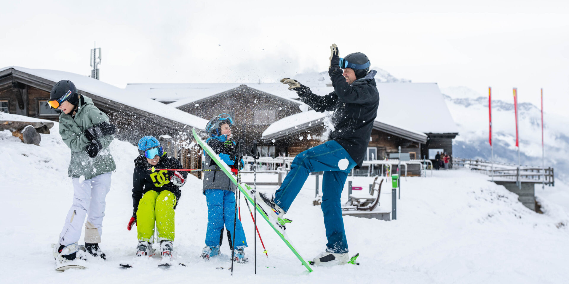 Schneeballschlacht mit dem Berghaus Schwänzelegg im Hintergrund