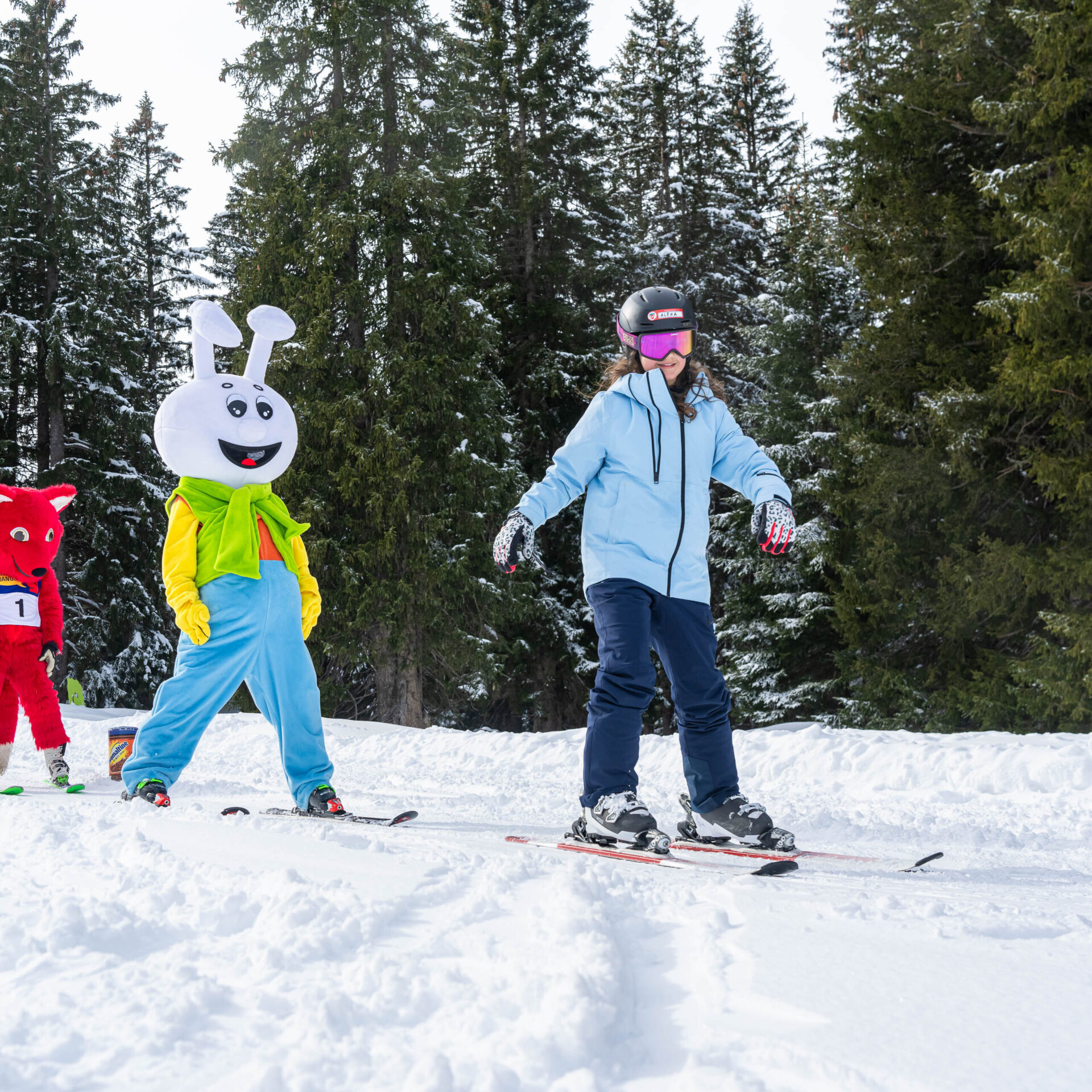 Eine junge Skifahrerin im Kinderland vor dem Snowli und dem Danusa-Fuchs