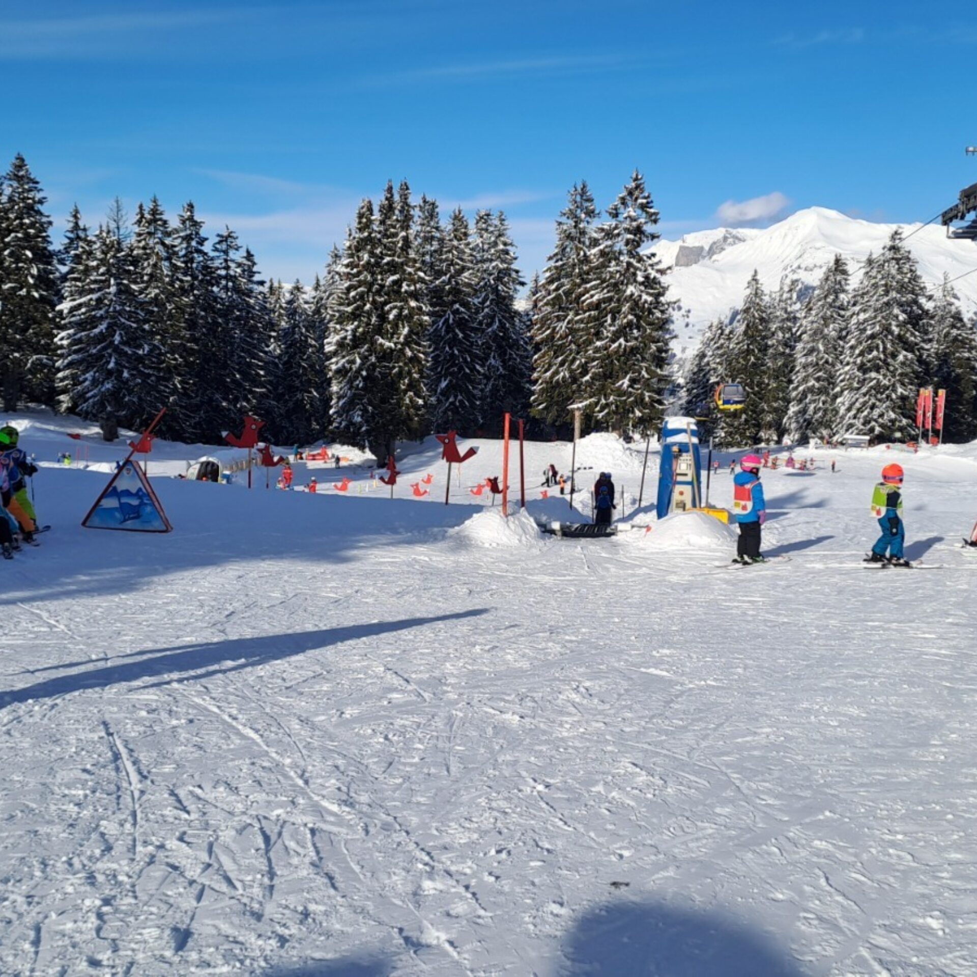 Kinderland mit Gondelbahn rechts und Skischule links