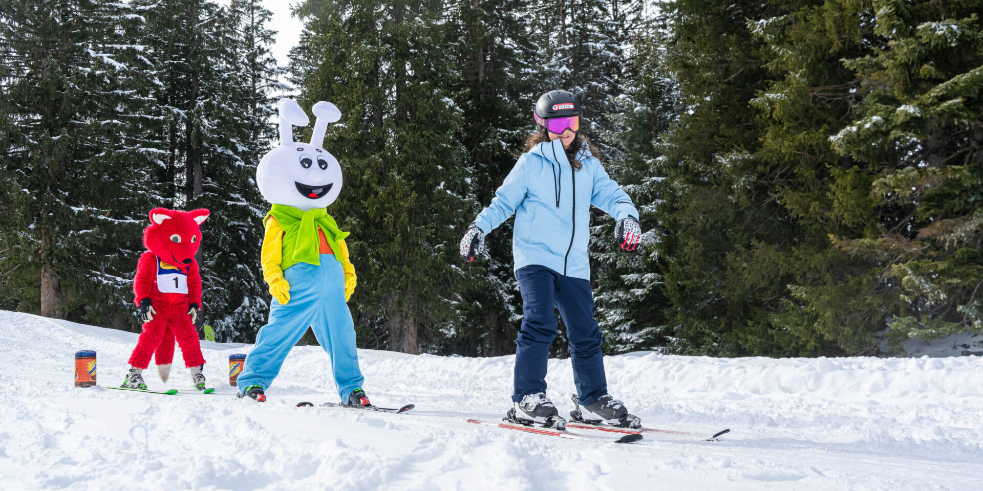 Eine junge Skifahrerin im Kinderland vor dem Snowli und dem Danusa-Fuchs