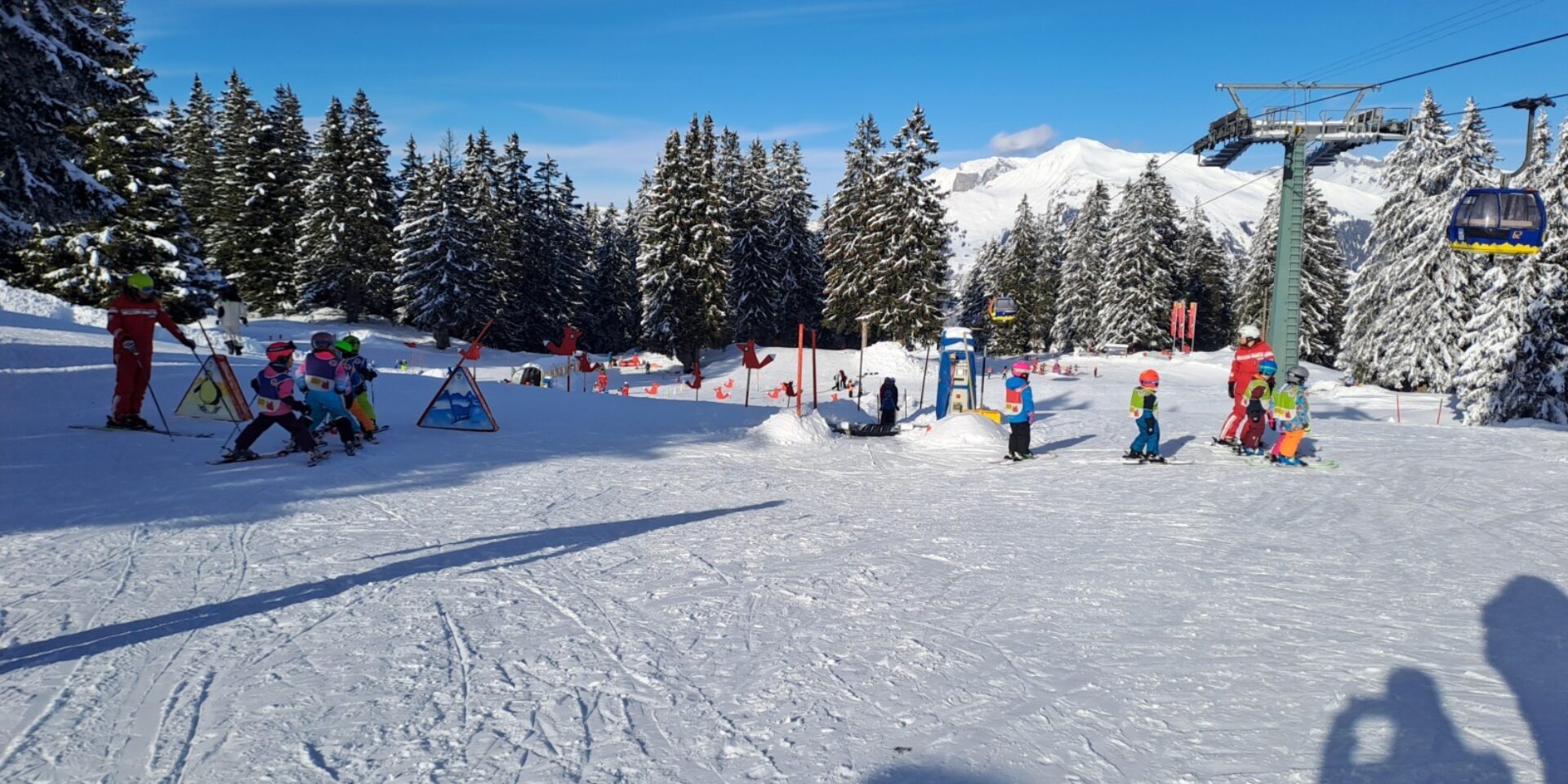 Kinderland mit Gondelbahn rechts und Skischule links