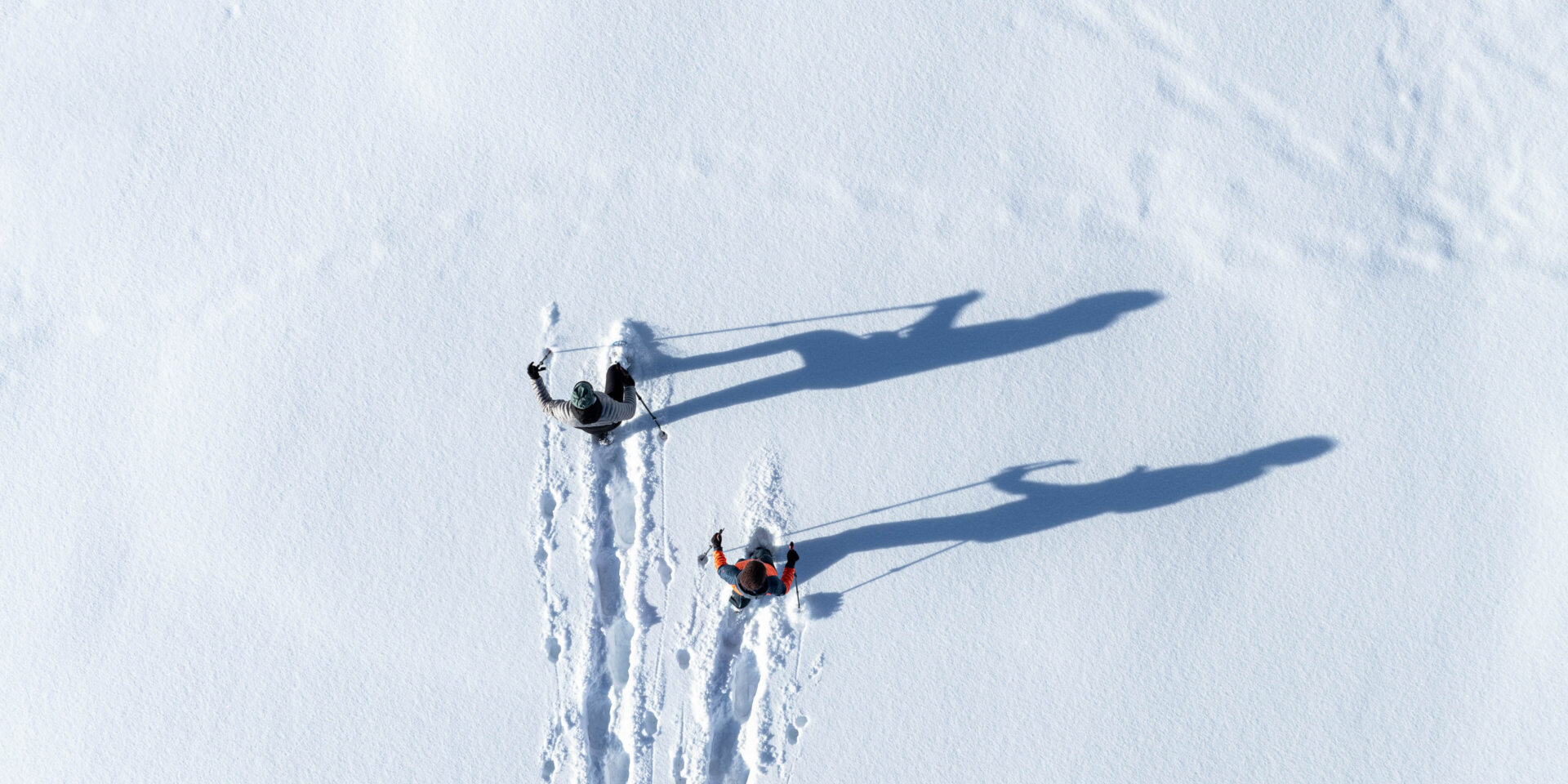 Zwei Schneeschuhwanderer von der Vogelperspektive im Tiefschnee