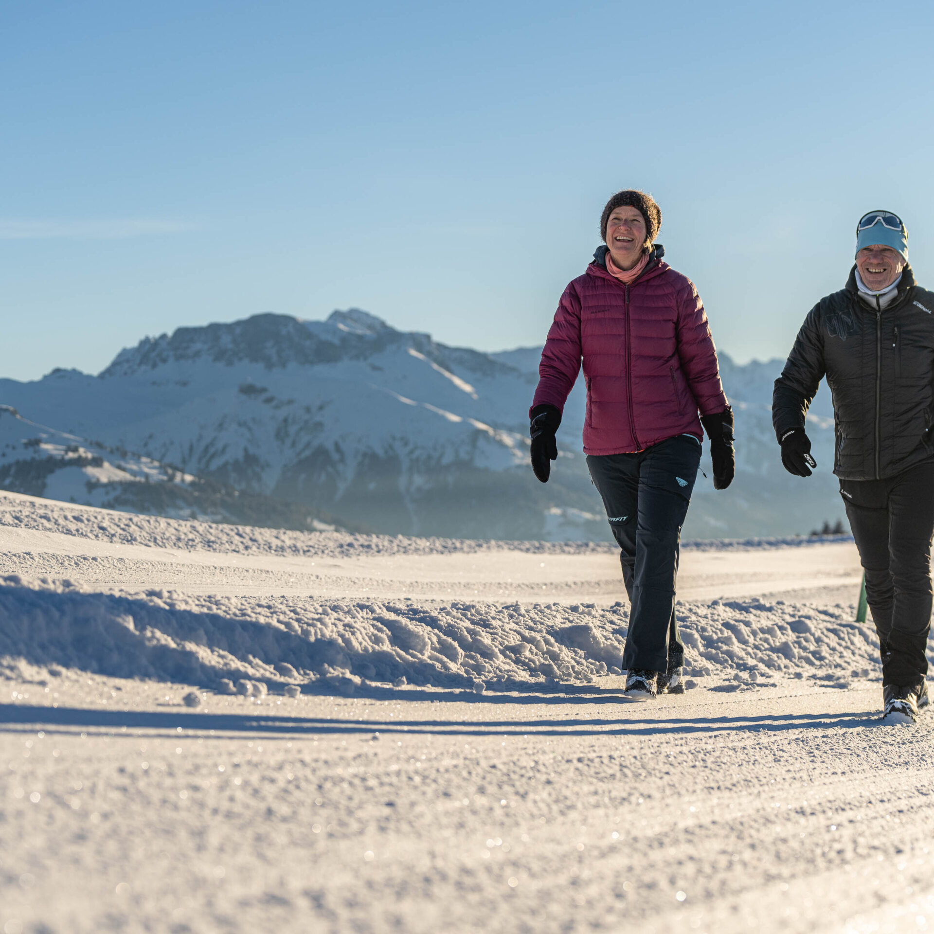 Mann und Frau am Winterwandern in der Morgensonne